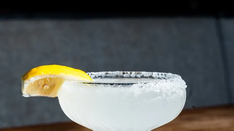 Lemon Drop cocktail — pale citrus drink in a coupe glass with a sugared rim and lemon wedge