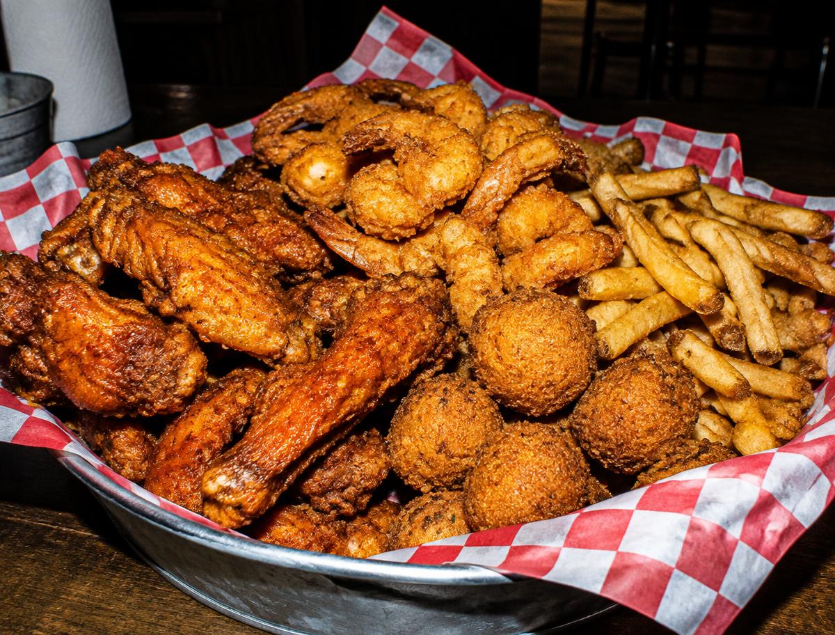 Wings, fried shrimp, and fries in a basket at Big Crab on Normandy Blvd